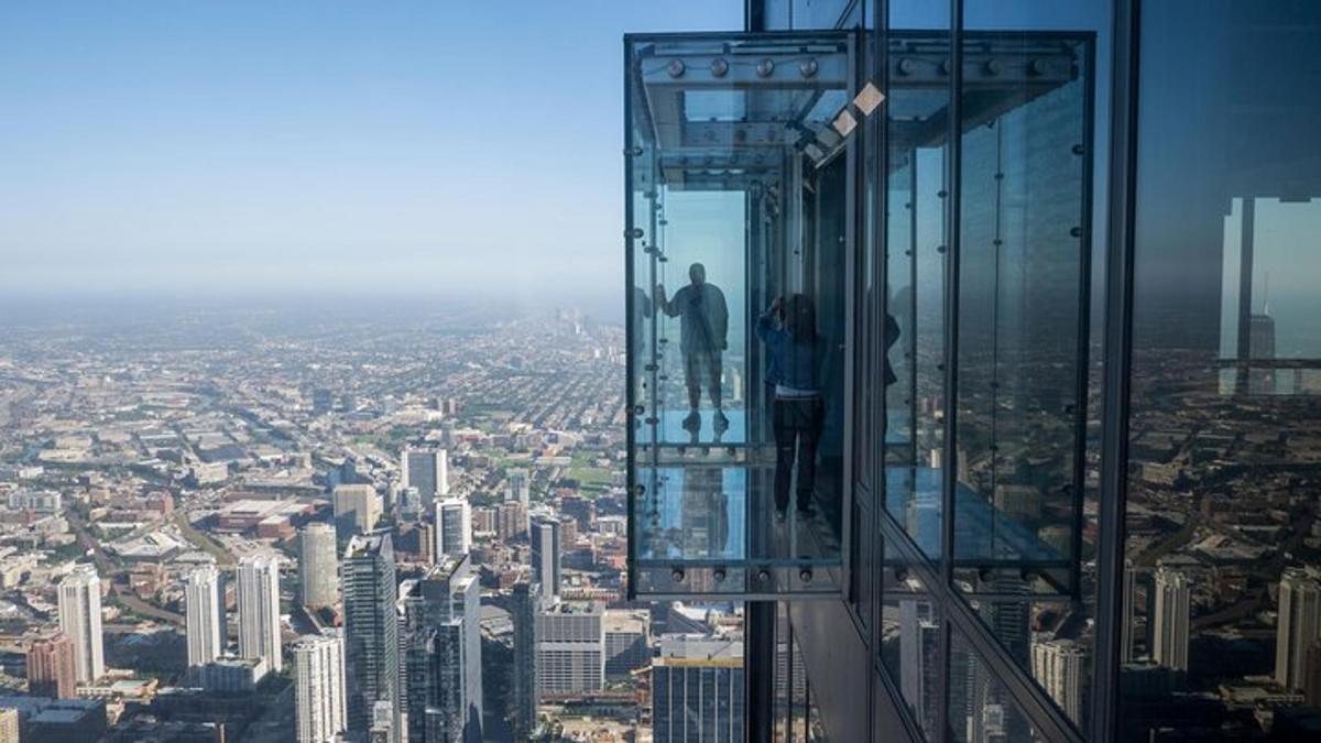 a man standing on the edge of a glass tower