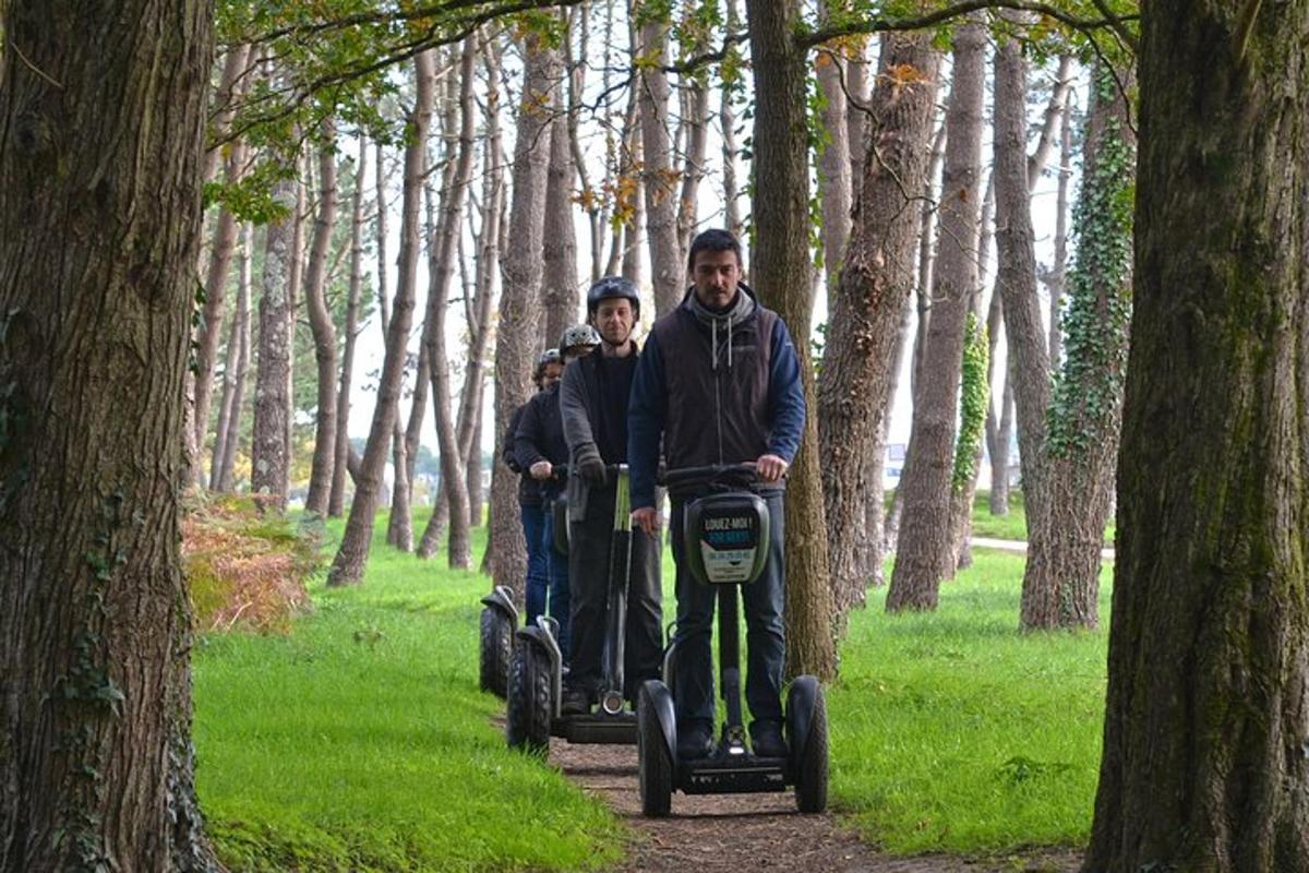 two people riding segways on a path in the woods