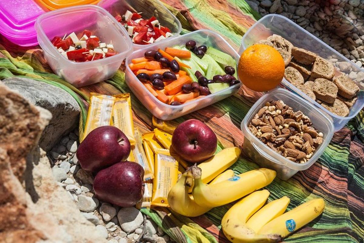 a table topped with plastic containers filled with fruits and vegetables
