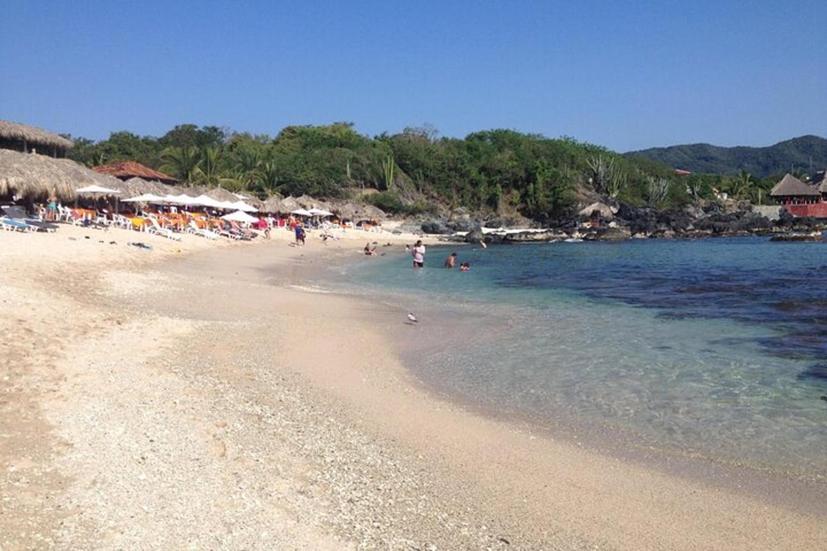 una spiaggia con un gruppo di persone in acqua