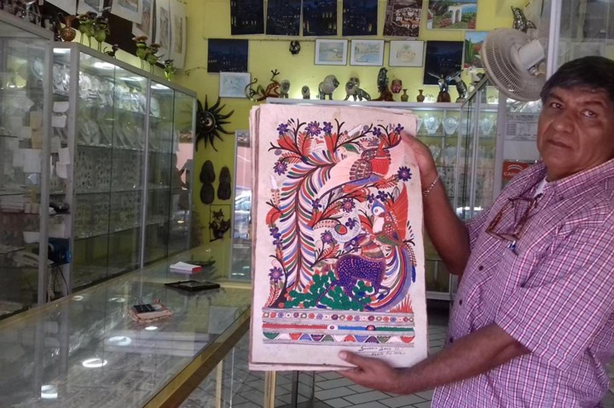 un home que sosté una pintura d'un drac