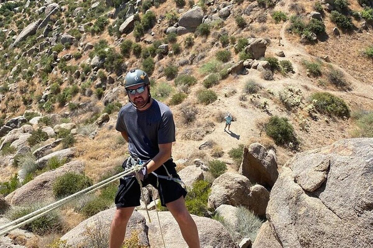 un uomo in piedi su una montagna con un palo
