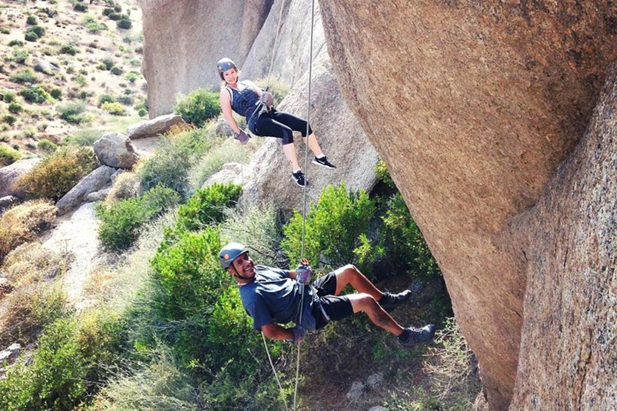 un uomo e una donna che si arrampicano su una formazione rocciosa