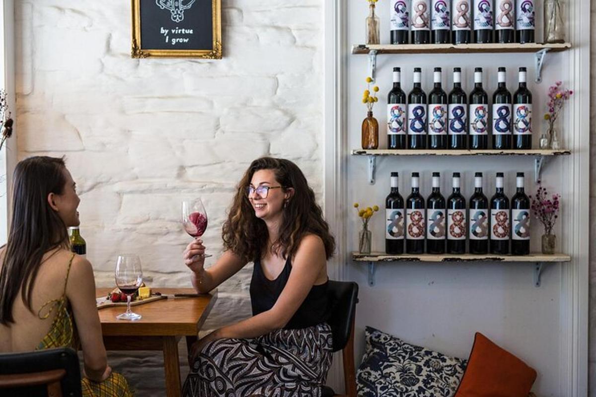 due donne sedute a un tavolo con un bicchiere di vino