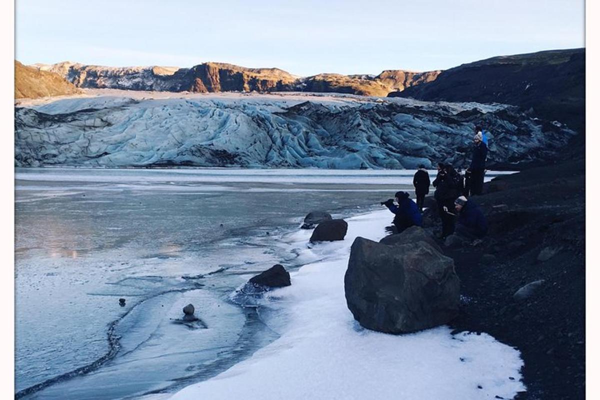 a group of people standing on a glacier in the snow