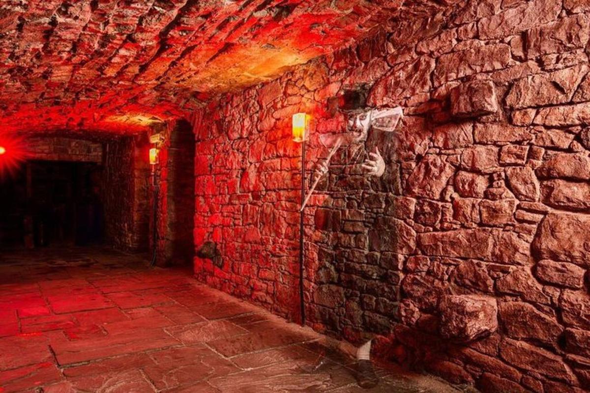 a brick hallway with a brick wall with red lights
