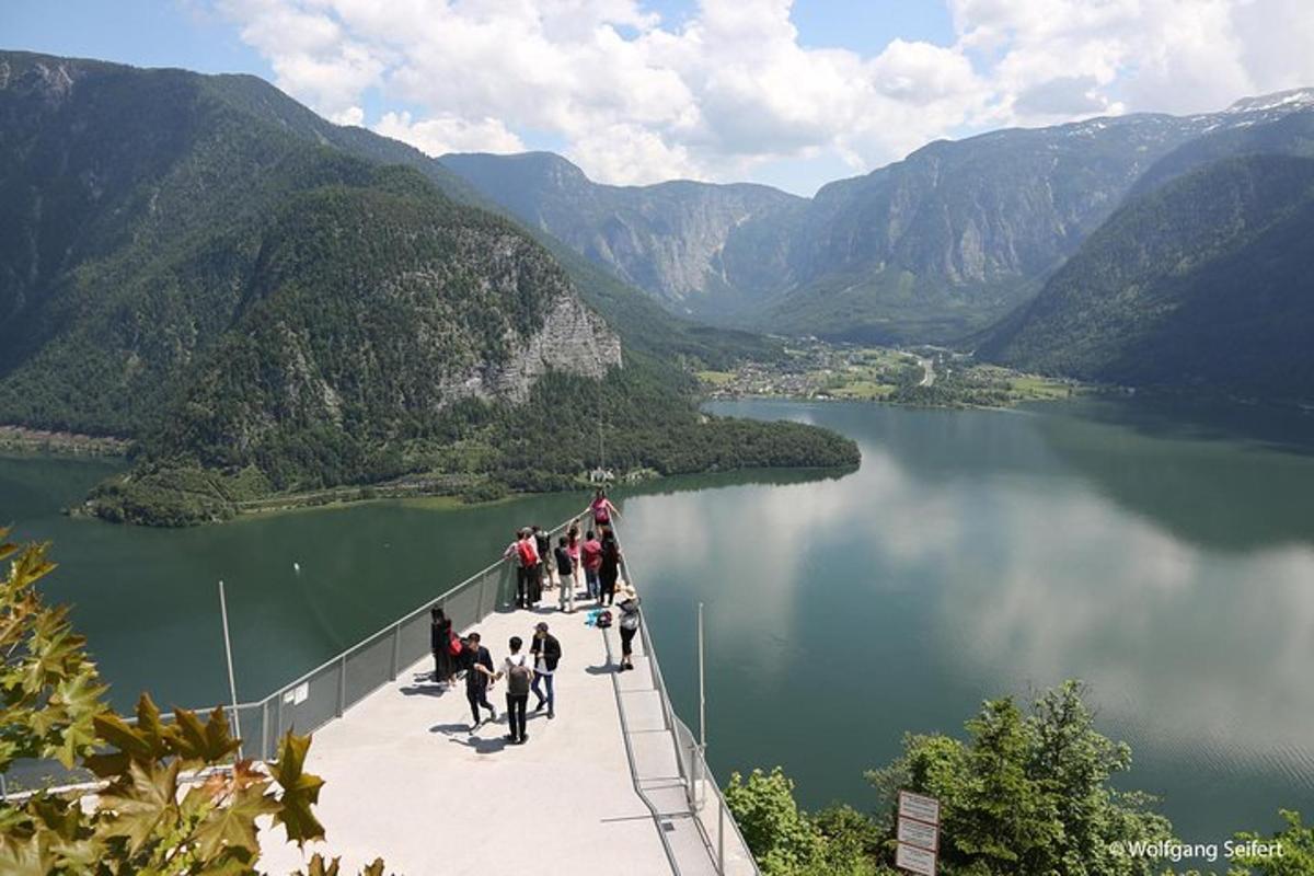 a group of people walking across a bridge over a lake