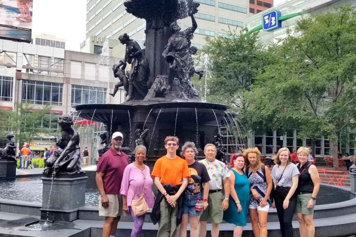 a group of people standing in front of a fountain