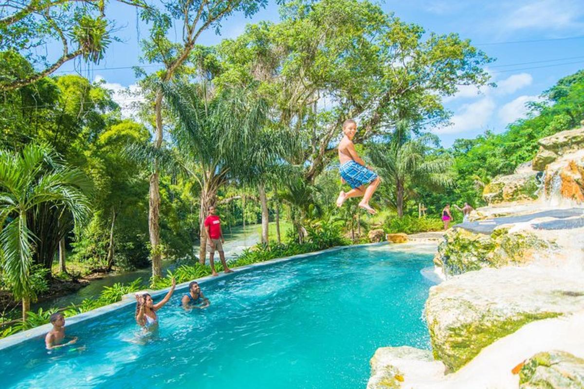 um menino pulando em uma piscina de um resort