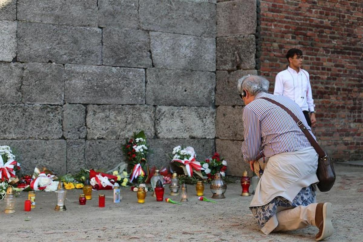 an older man standing in front of a war memorial