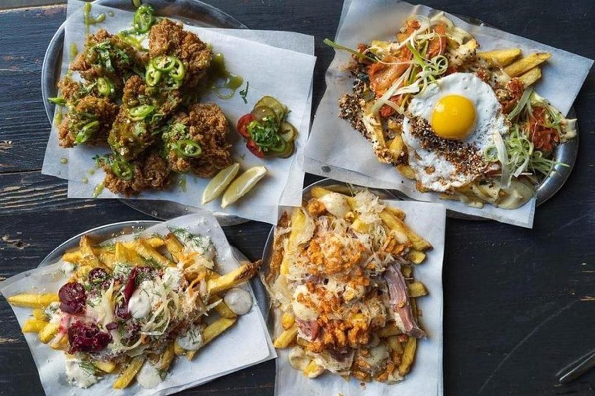 meja dengan pinggan berisi makanan dan telur serta kentang goreng