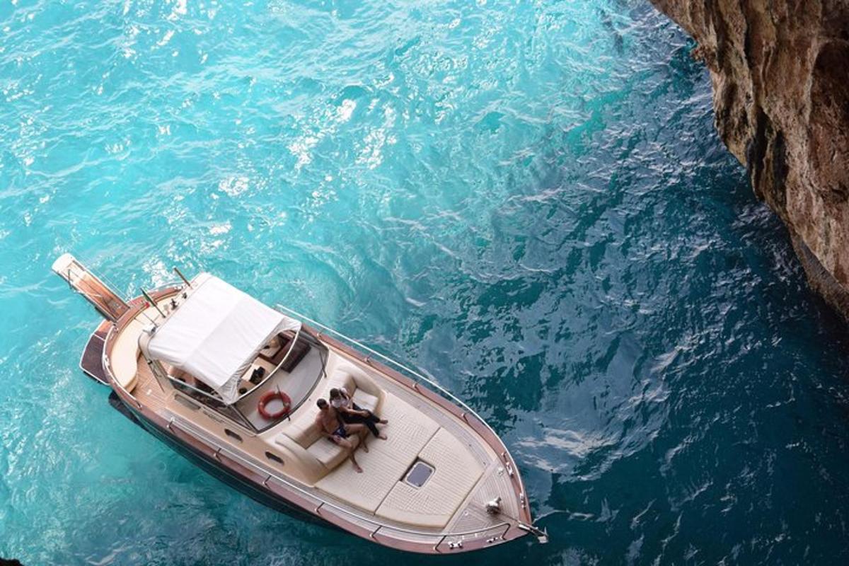 un barco en el agua junto a un acantilado