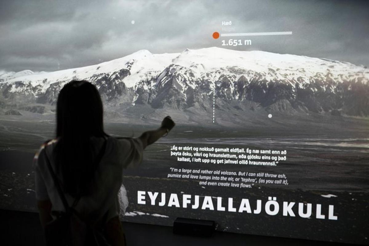 a woman pointing at a mountain with a poster