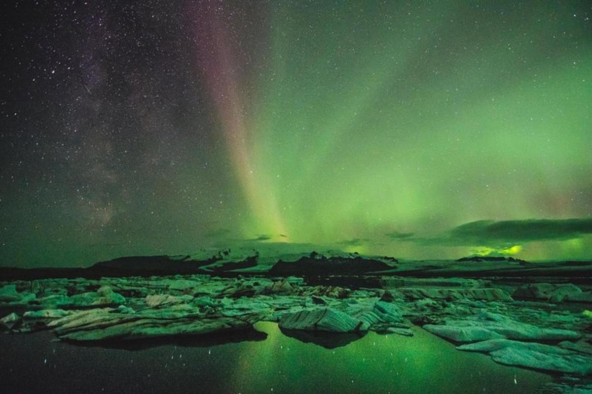 Una aurora sobre un glaciar con icebergs en un campo.