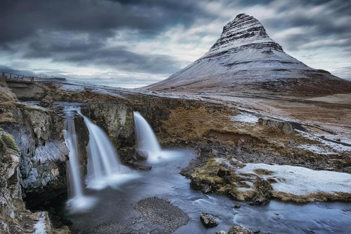 a mountain with a waterfall in front of a river