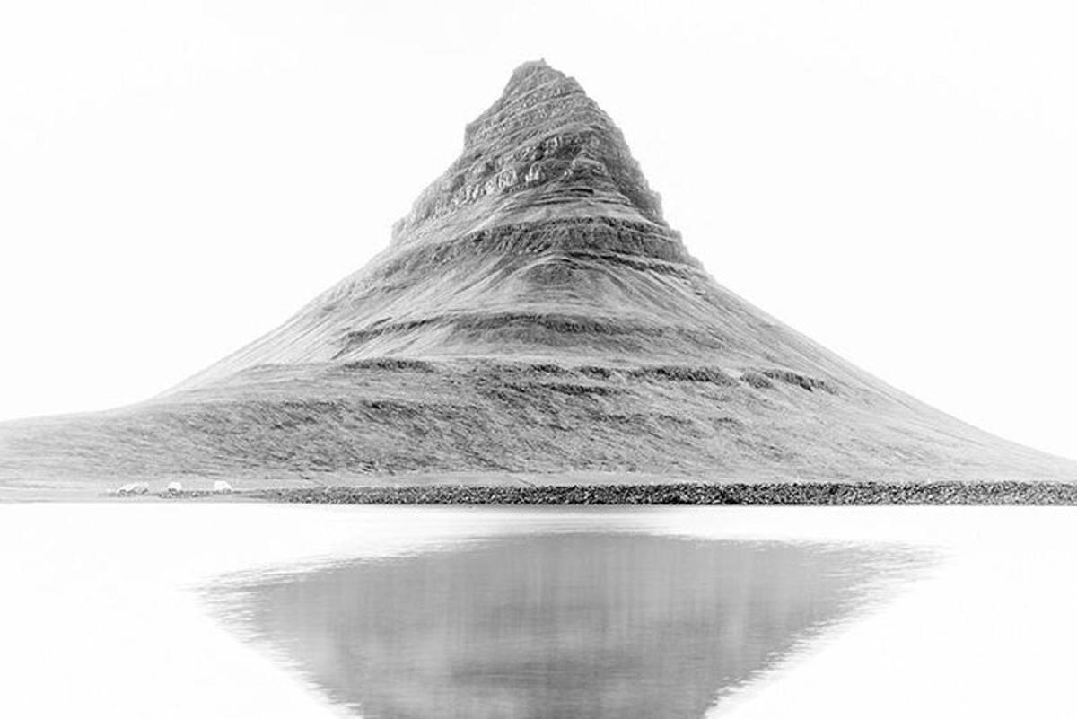 a straw hill with its reflection in the water