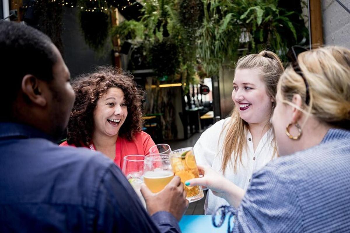 a group of people sitting around a table drinking beer
