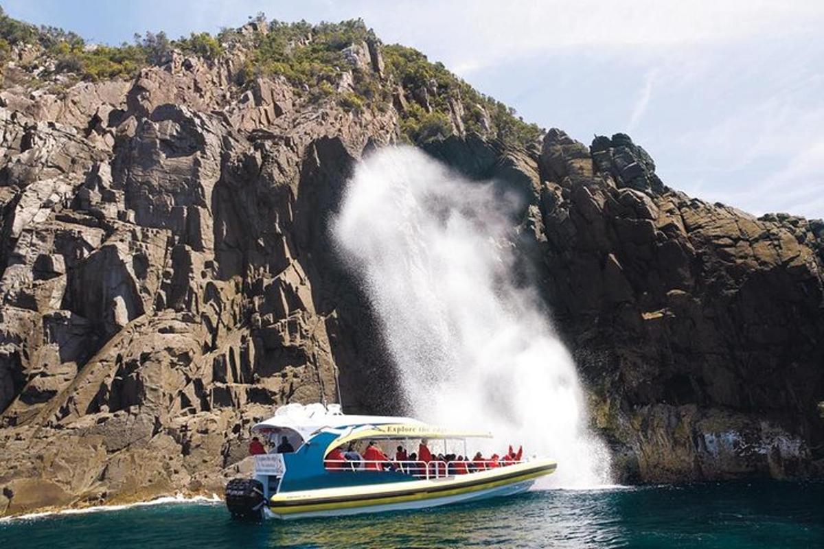 a group of people on a boat in front of a waterfall