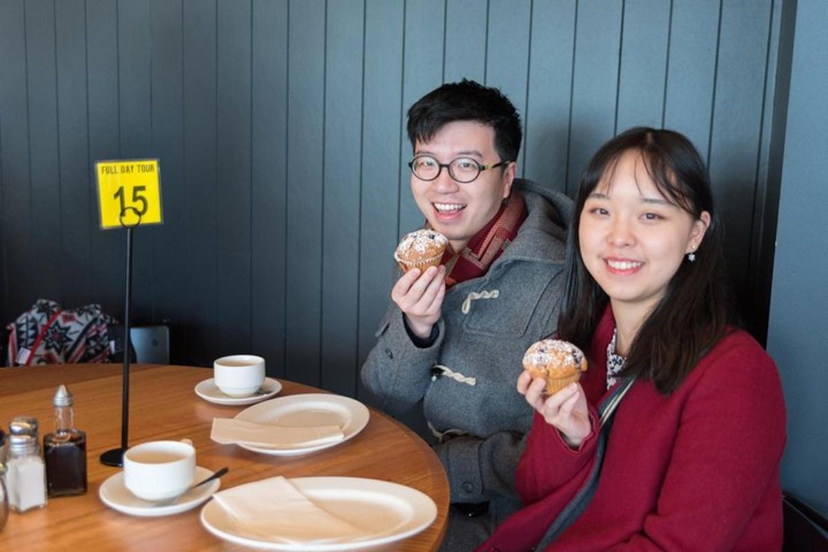 a man and a woman sitting at a table eating donuts