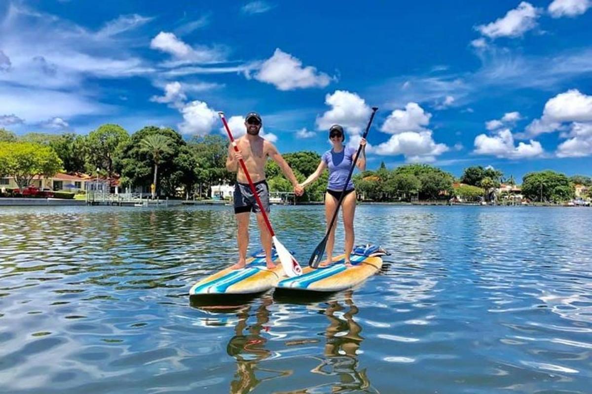 un uomo e una donna su tavole da paddle in acqua