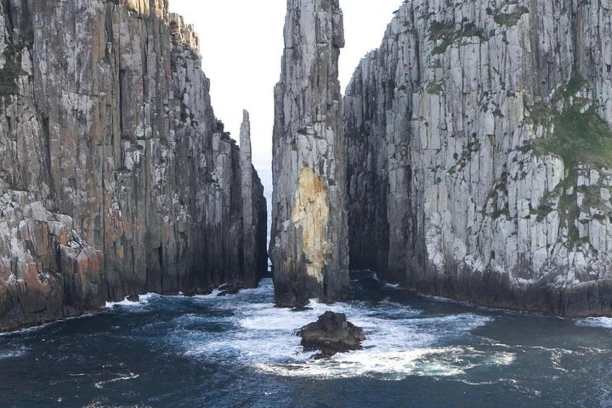 un dipinto di un fiume tra due grandi rocce