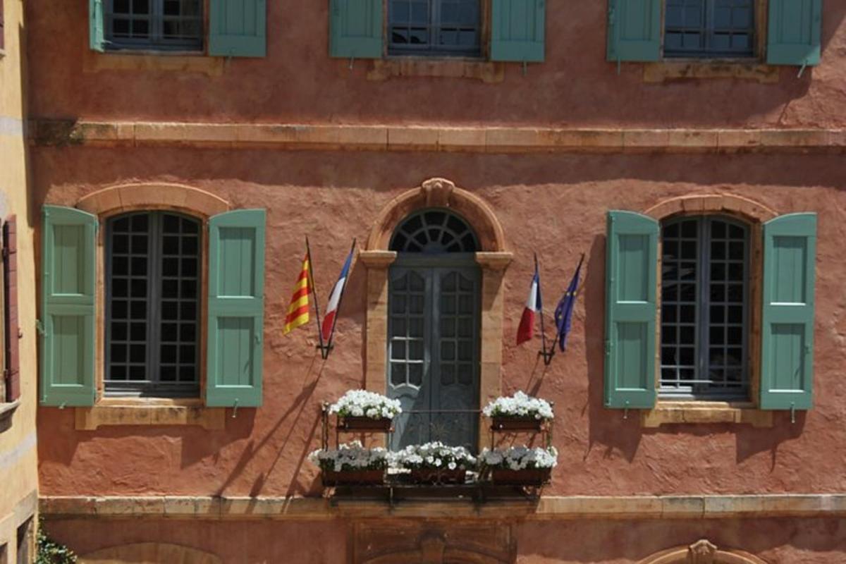 un edificio con persiane verdi e fiori su una finestra