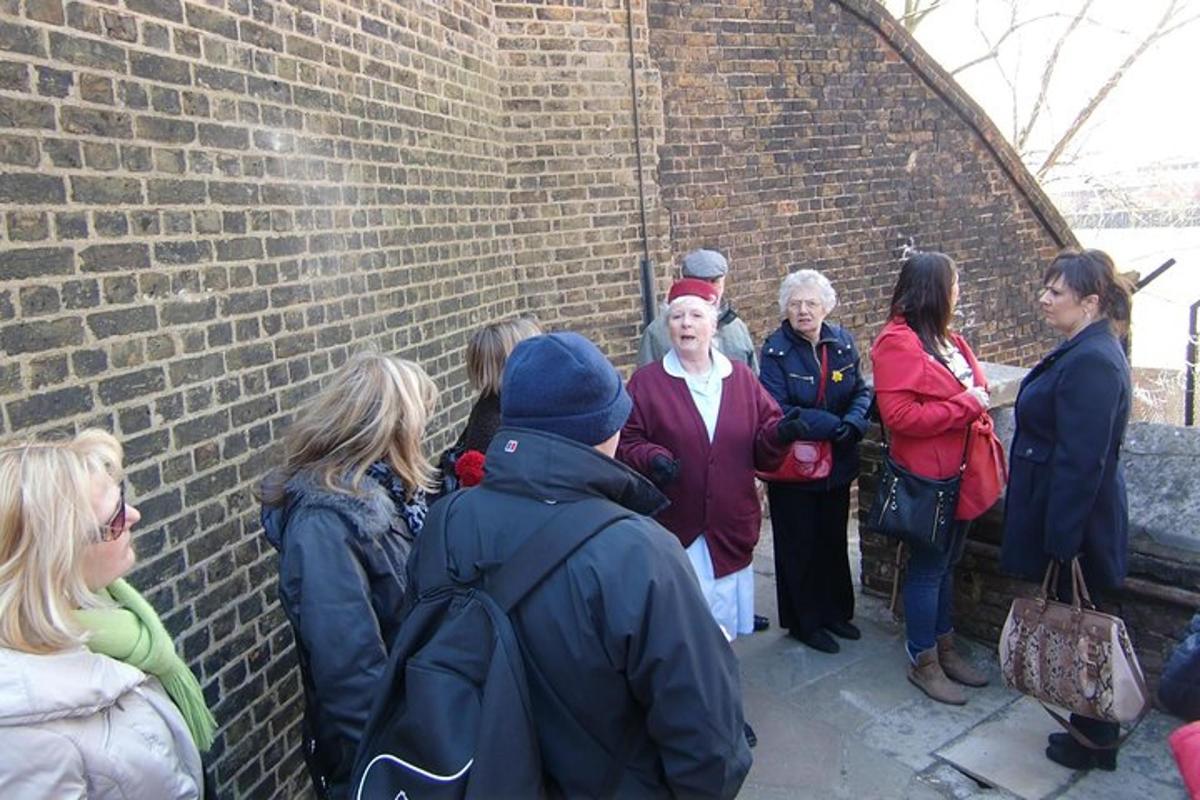 a group of people standing next to a brick wall