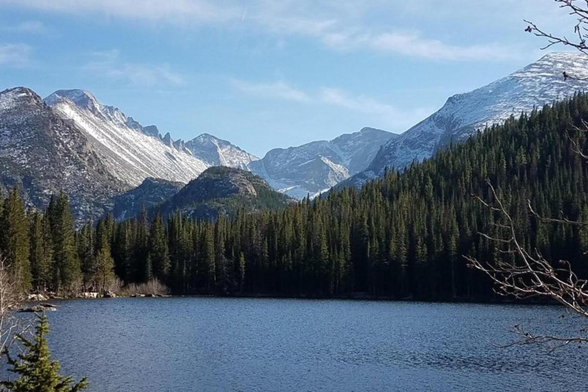 a lake in the middle of a forest with mountains