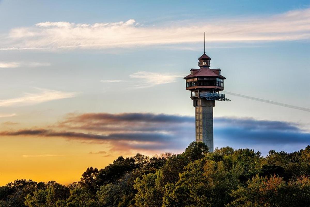 a tower on top of a hill with a sunset