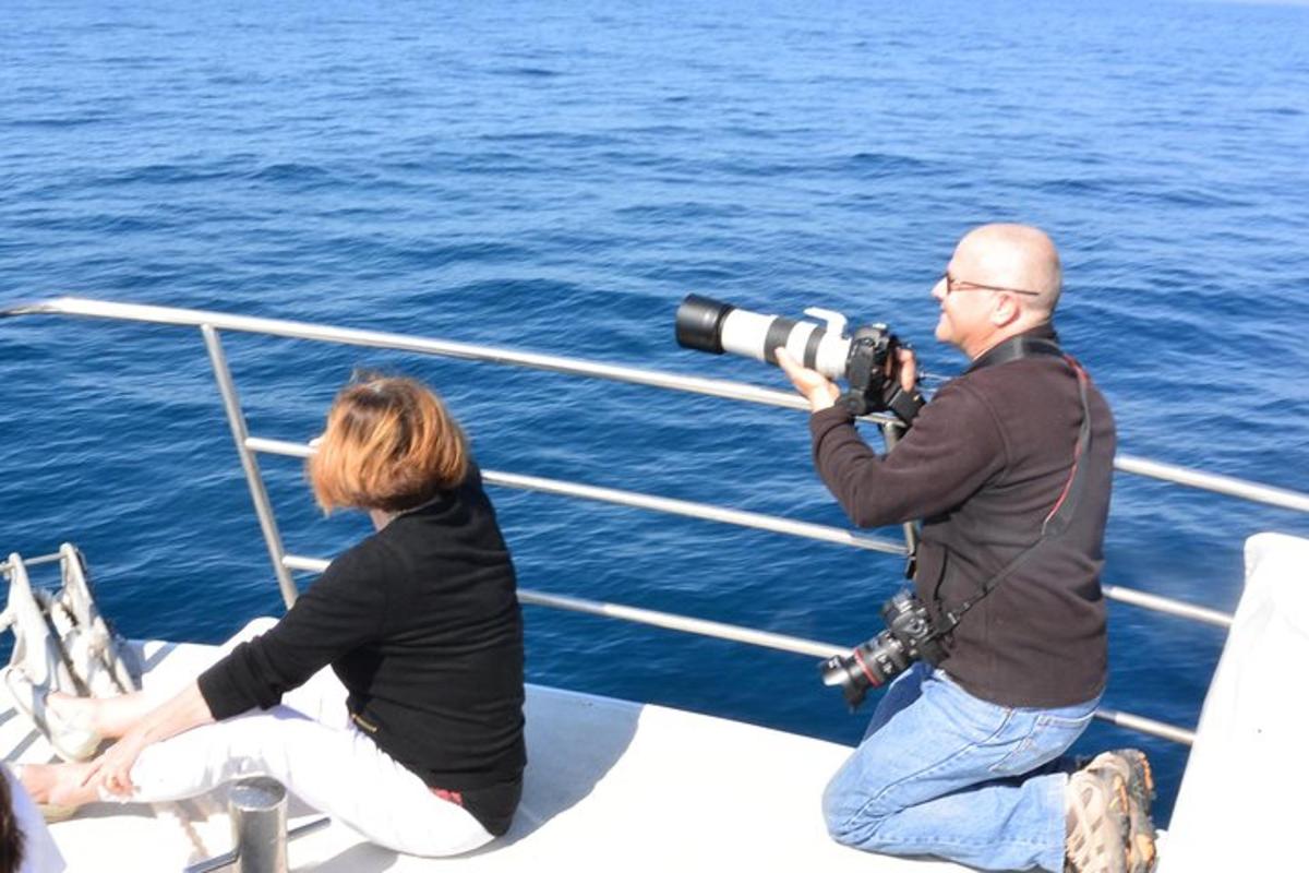 a woman taking a picture of a man with a camera on a boat