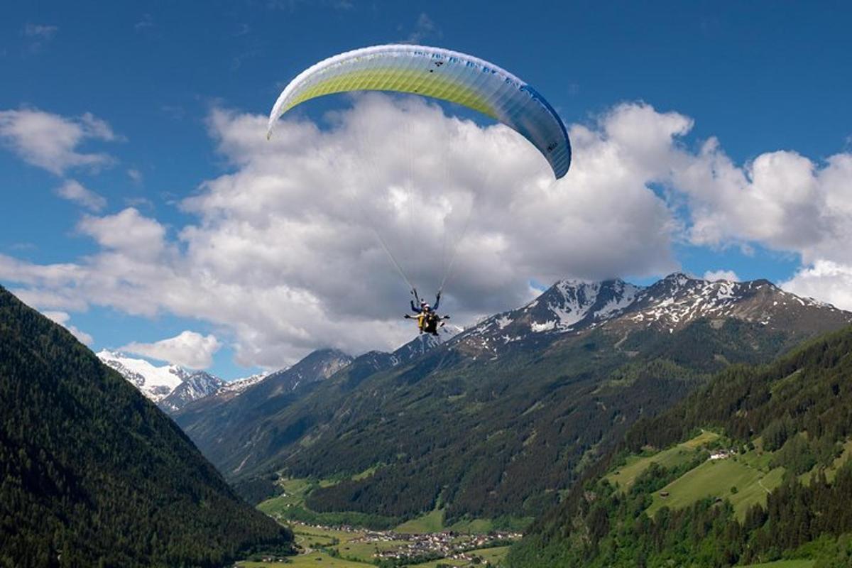 a person is flying with a parachute over a mountain