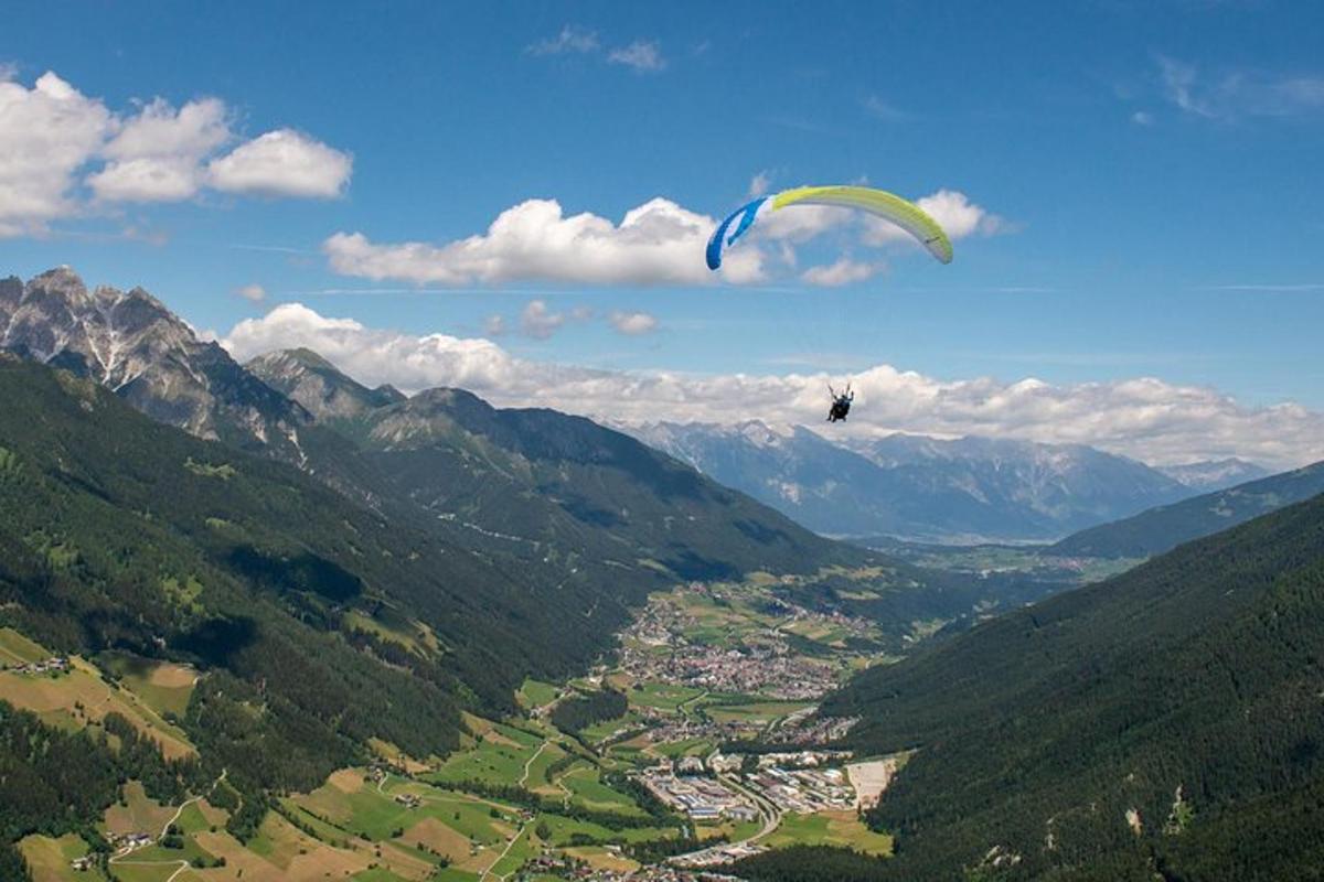 a person flying a kite in the air over a valley
