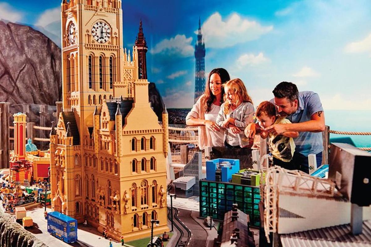 a group of people standing next to a model of a clock tower
