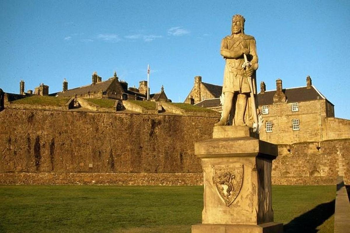 eine Statue eines Mannes, der vor einem Schloss steht