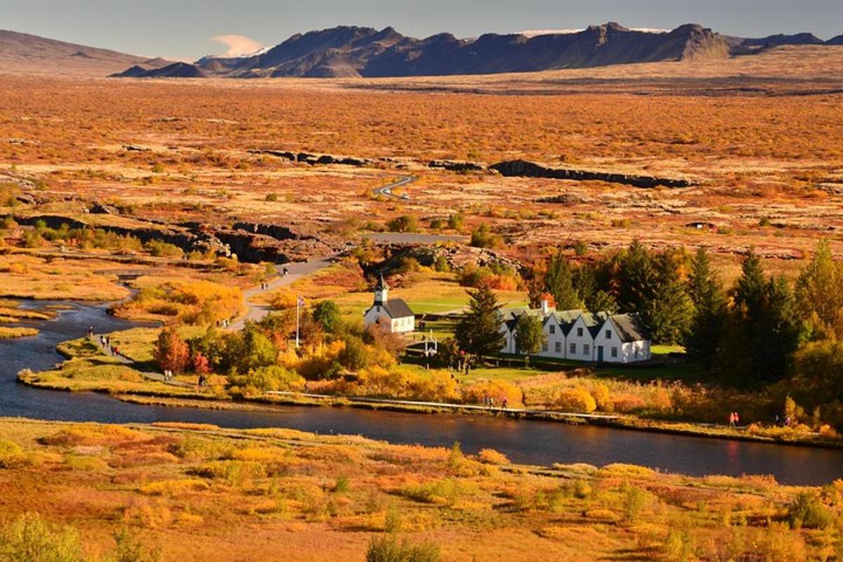 a house in the middle of a field next to a river