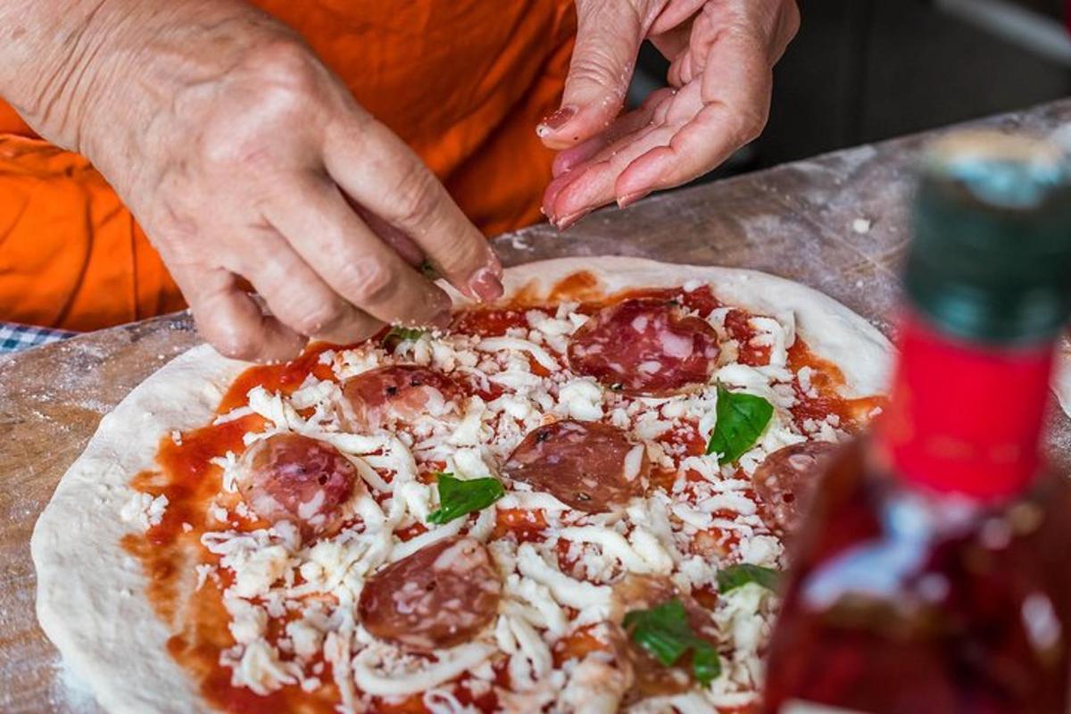 inimene, kes katab pitsat pepperoni ja juustuga