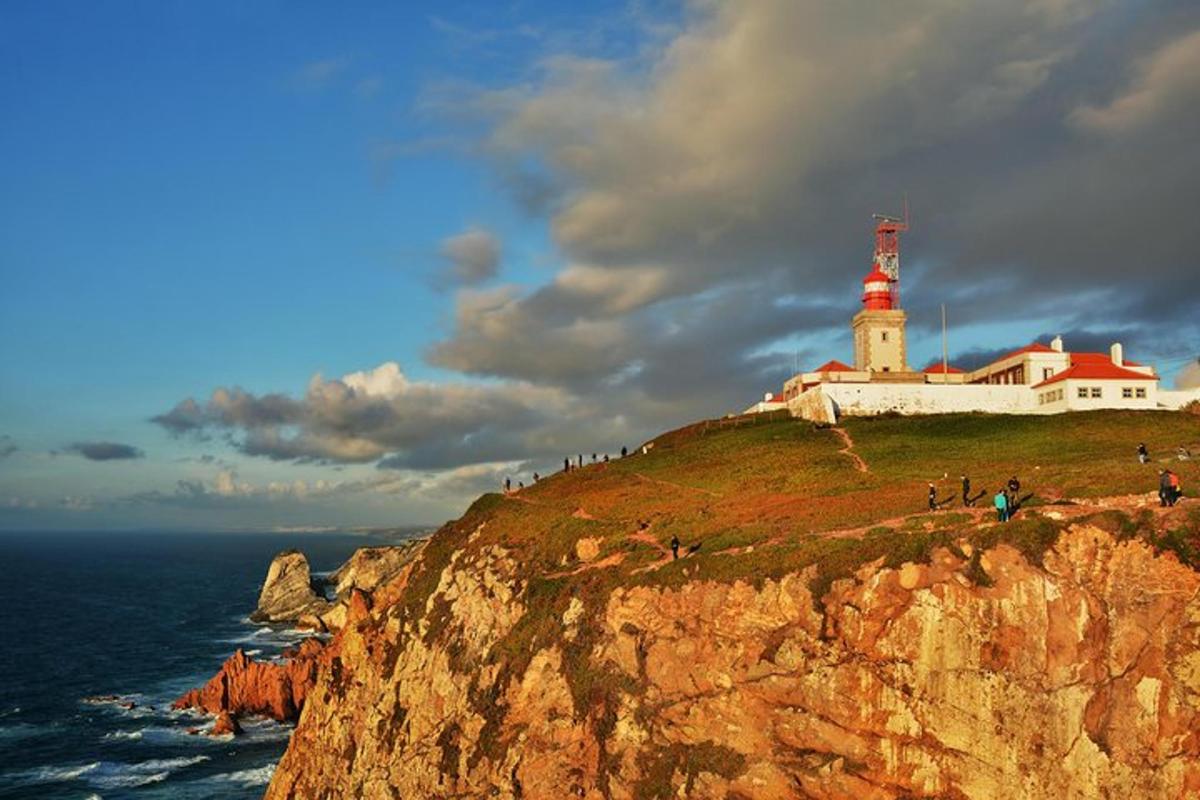 a lighthouse on top of a cliff next to the ocean