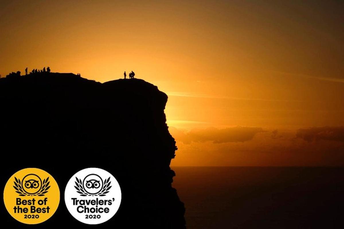 maður stendur á fjallstoppi við sólsetur