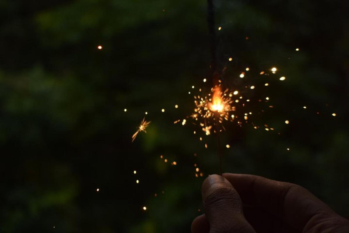 a person holding up a sparkler in the dark