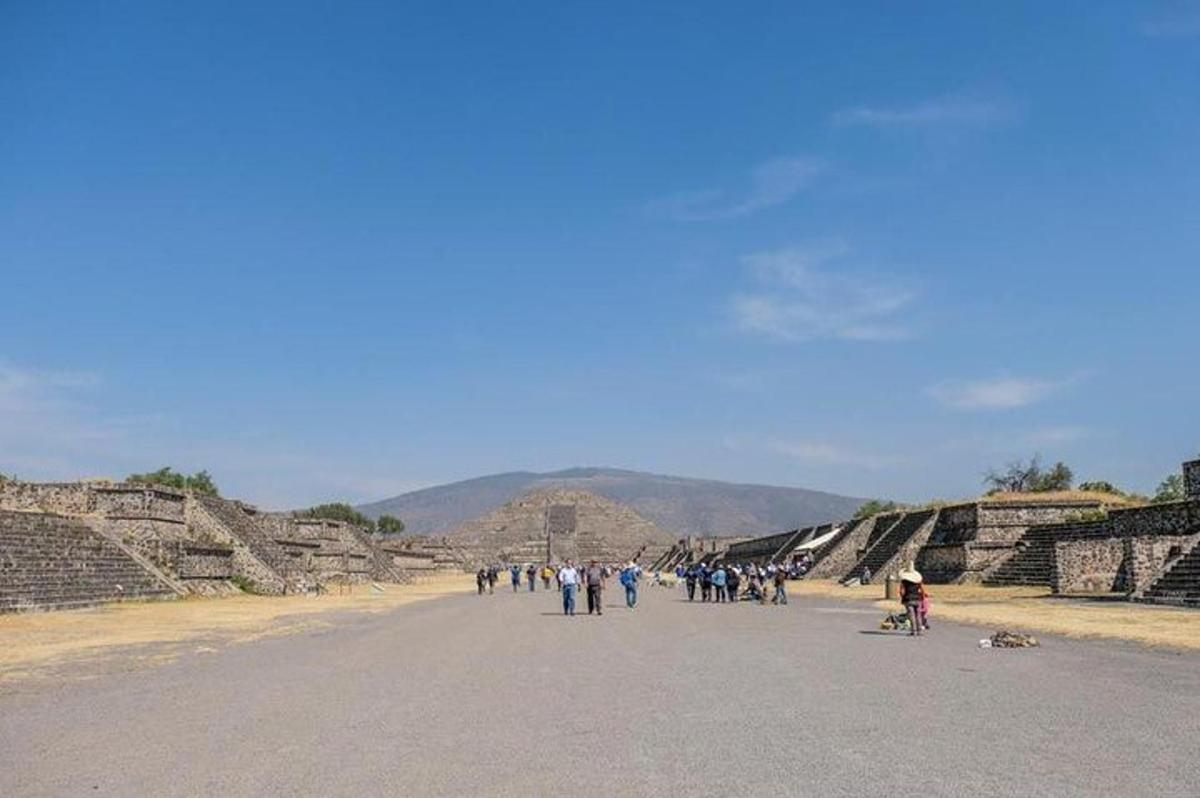 skupina lidí jdoucích po silnici u pyramid