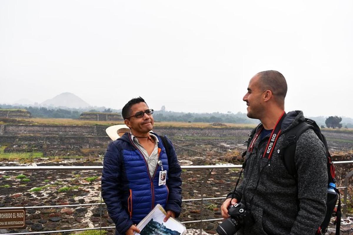two men standing next to each other in a field