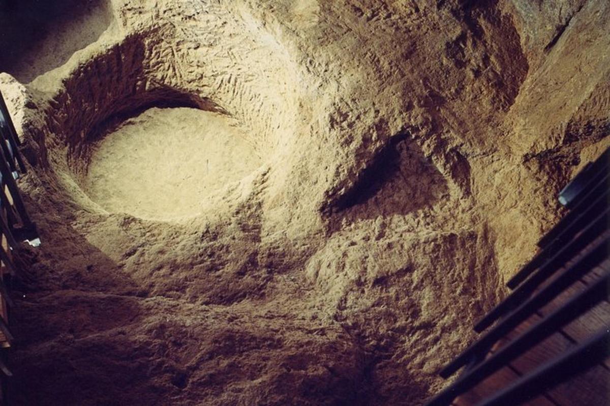 a stone bowl with a hole in the ground