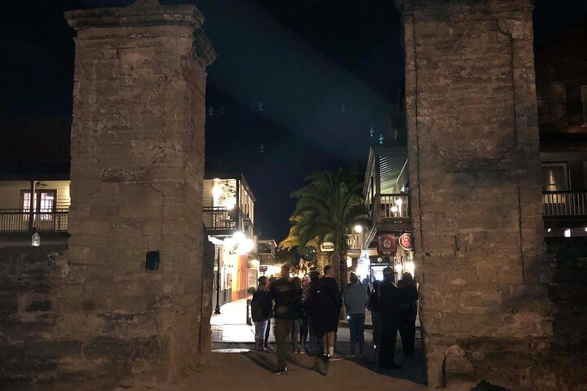 a group of people walking down a street at night