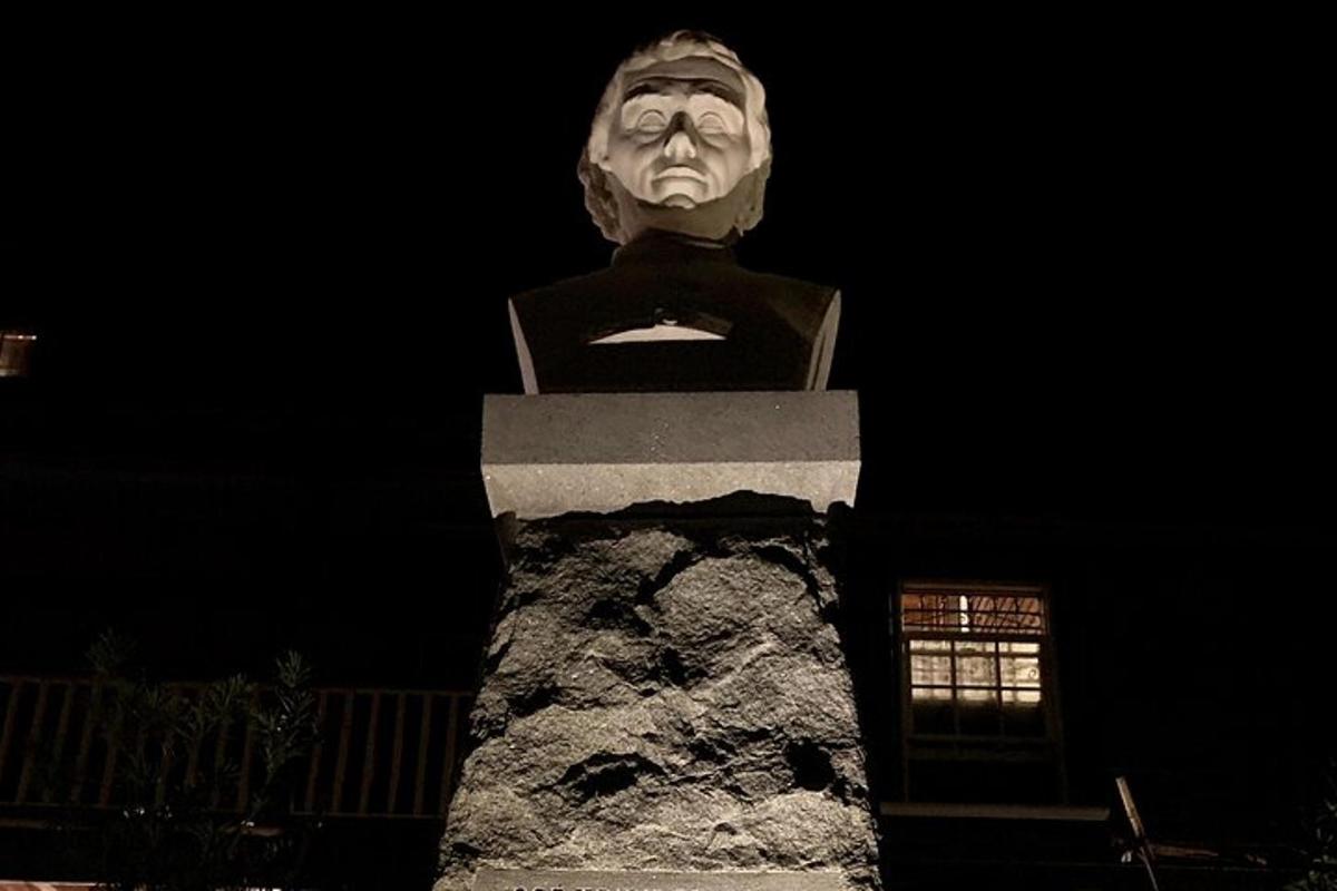 a statue of a man sitting on top of a rock
