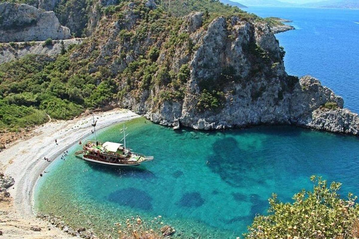 a boat sitting on a beach next to a cliff