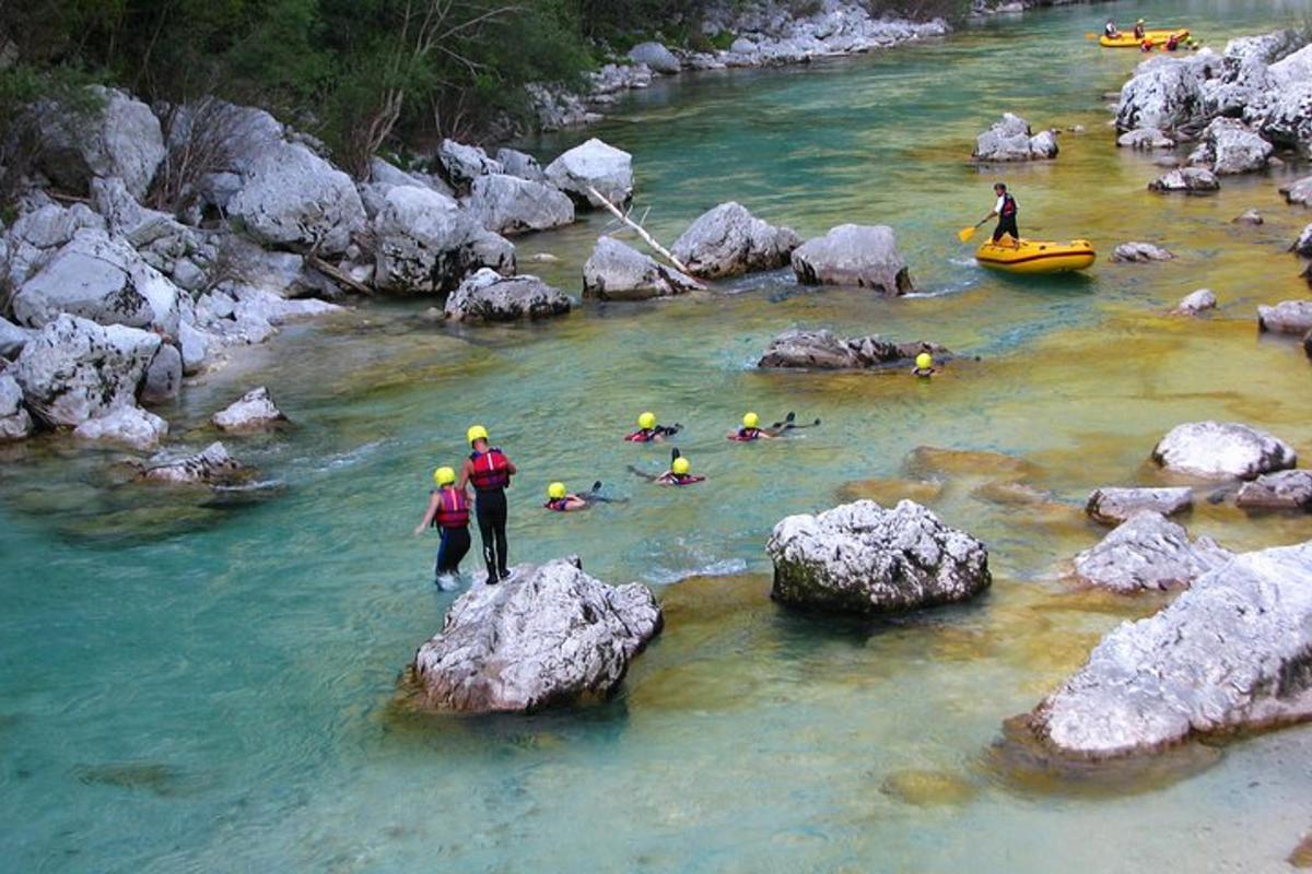 a group of people in a river with rocks