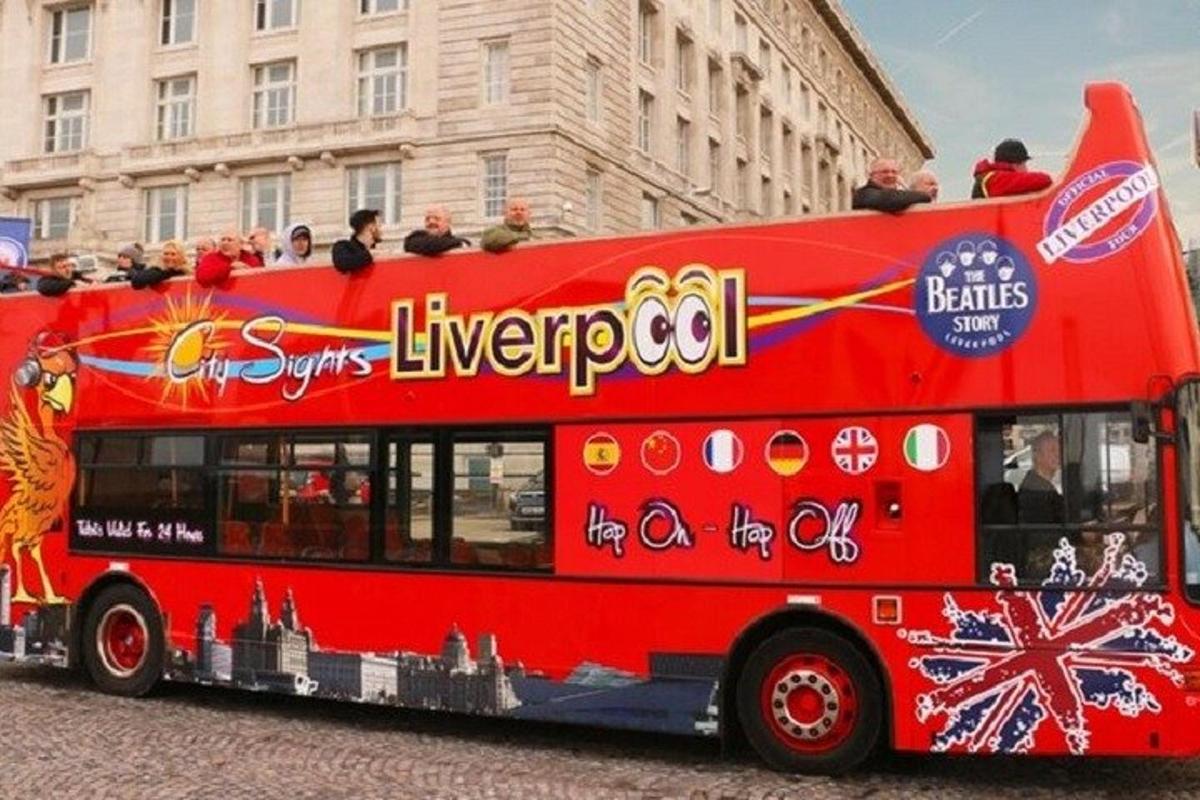 červený dvoupatrový autobus jedoucí po ulici