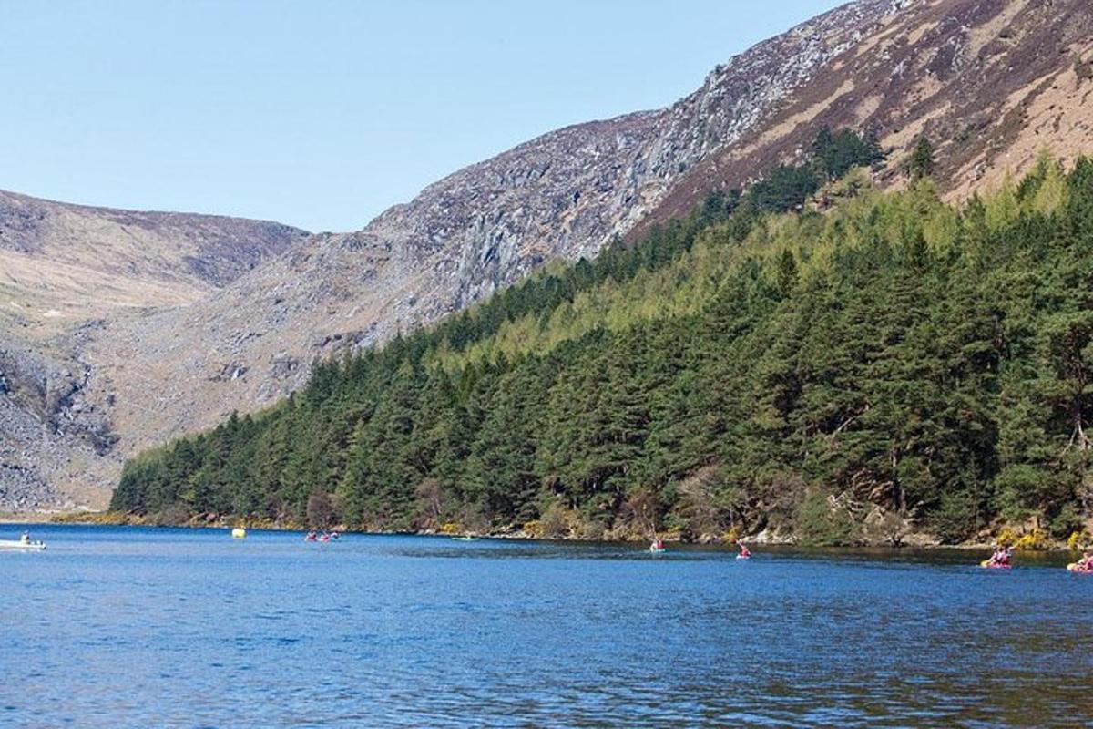 un grup de persones fent caiac en un llac davant d'una muntanya