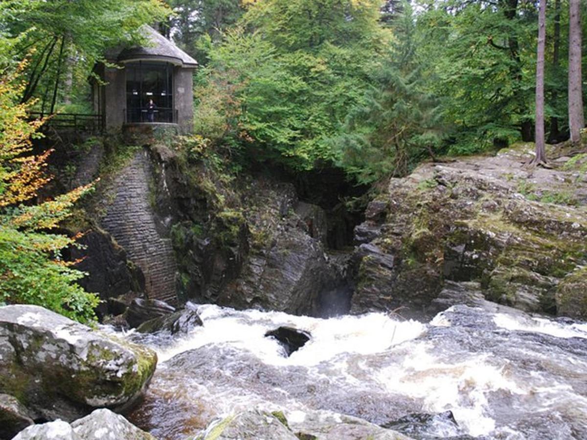 sebuah bangunan di sisi sungai dengan air terjun