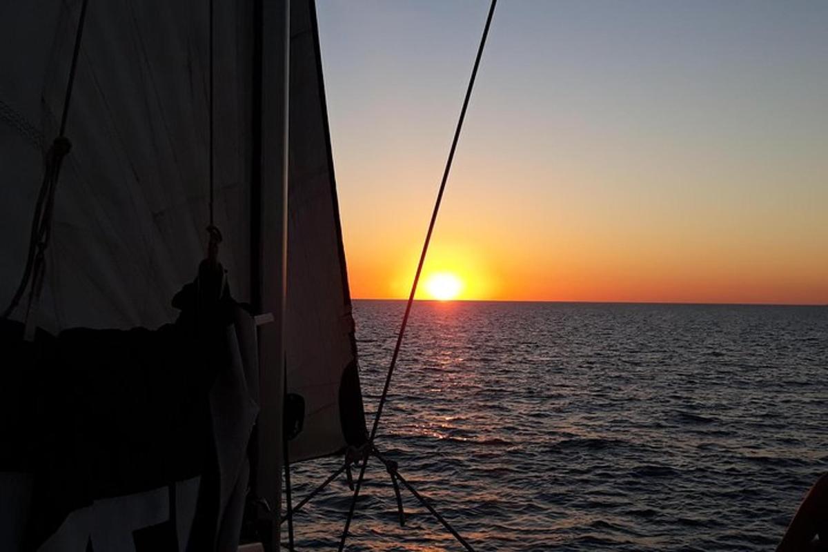 a person on a boat looking out at the sunset